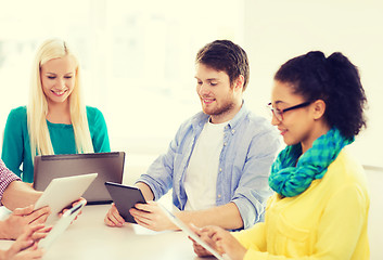 Image showing smiling team with table pc and laptop in office