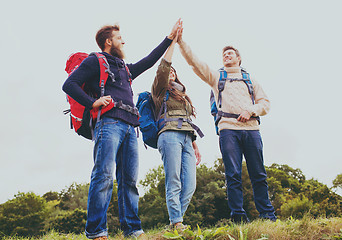 Image showing group of smiling friends with backpacks hiking