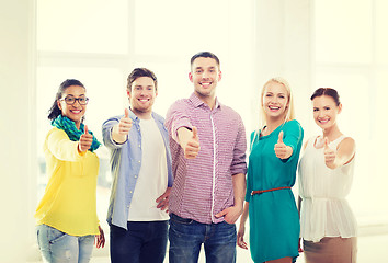 Image showing happy creative team showing thumbs up in office