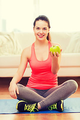 Image showing smiling teenage girl with green apple at home
