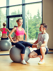 Image showing smiling man and woman with exercise ball in gym