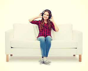 Image showing teenage girl sitting on sofa with headphones