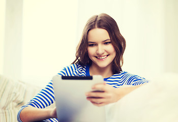 Image showing smiling teenage girl with tablet pc at home