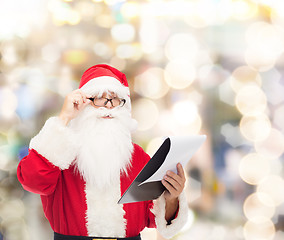 Image showing man in costume of santa claus with notepad