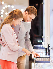 Image showing happy couple choosing engagement ring in mall