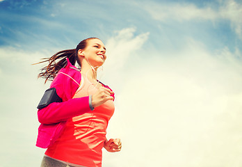 Image showing smiling young woman running outdoors