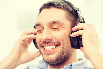 Image showing smiling young man in headphones at home