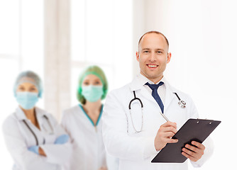 Image showing smiling male doctor with clipboard and stethoscope