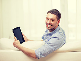 Image showing smiling man working with tablet pc at home