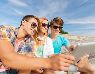 Image showing group of smiling friends with tablet pc outdoors