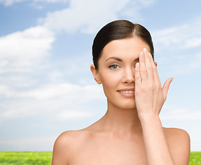 Image showing smiling young woman covering face with hand