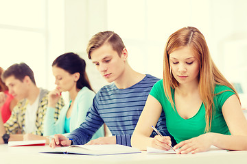 Image showing tired students with textbooks and books at school