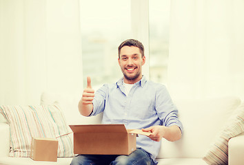 Image showing man with cardboard boxes at home showing thumbs up