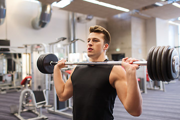 Image showing young man flexing muscles with barbell in gym