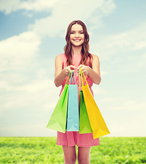 Image showing smiling woman in dress with many shopping bags