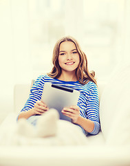 Image showing smiling teenage girl with tablet pc at home