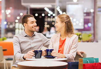 Image showing happy couple with shopping bags drinking coffee