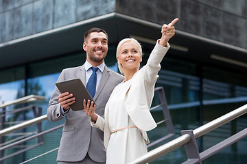 Image showing smiling businessmen with tablet pc outdoors