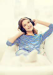 Image showing smiling young girl in headphones at home