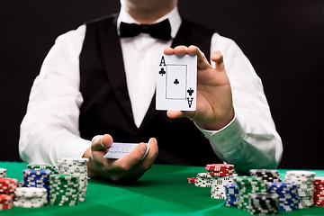 Image showing holdem dealer with playing cards and casino chips