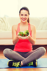 Image showing smiling teenage girl with green salad at home