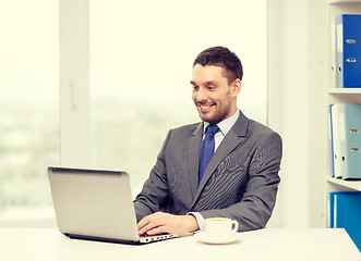 Image showing smiling businessman with laptop and coffee