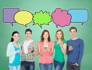 Image showing happy friends showing blank smartphones screens