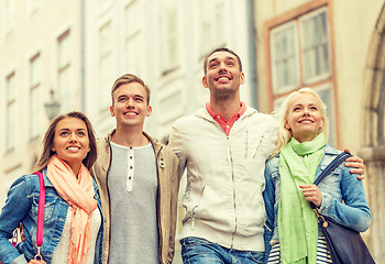 Image showing group of smiling friends walking in the city