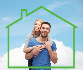 Image showing smiling couple hugging over green house