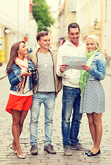 Image showing group of smiling friends with map and photocamera