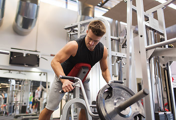 Image showing young man exercising on t-bar row machine in gym