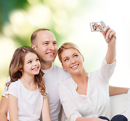 Image showing happy family with camera at home