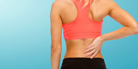 Image showing close up of sporty woman touching her back