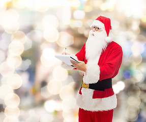 Image showing man in costume of santa claus with notepad