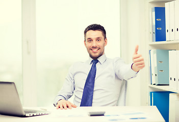 Image showing smiling businessman with laptop and documents