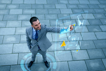 Image showing smiling businessman with virtual screens outdoors