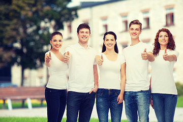 Image showing smiling teenagers in t-shirts showing thumbs up