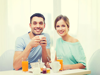 Image showing smiling couple having breakfast at home