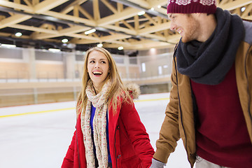 Image showing happy couple holding hands on skating rink