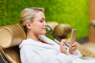 Image showing beautiful young woman with smartphone at spa