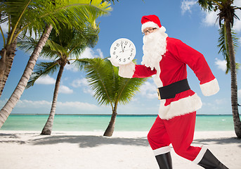 Image showing man in costume of santa claus with clock