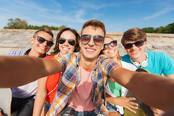 Image showing group of smiling friends making selfie outdoors