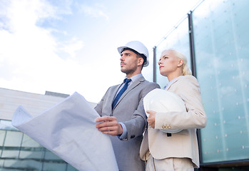 Image showing businessmen with blueprint and helmets