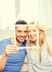 Image showing smiling couple with house from measuring tape