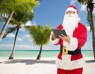 Image showing man in costume of santa claus with tablet pc