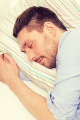 Image showing calm young man lying on sofa at home