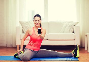 Image showing smiling teenage girl streching on floor at home