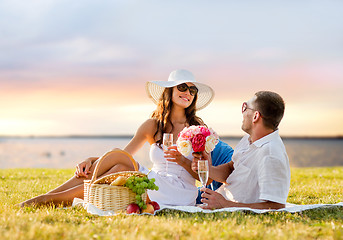 Image showing smiling couple drinking champagne on picnic