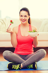 Image showing smiling teenage girl with green salad at home