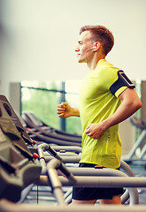 Image showing smiling man exercising on treadmill in gym